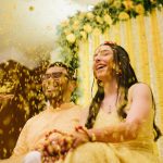 yellow flower shower on couple during haldi ceremony