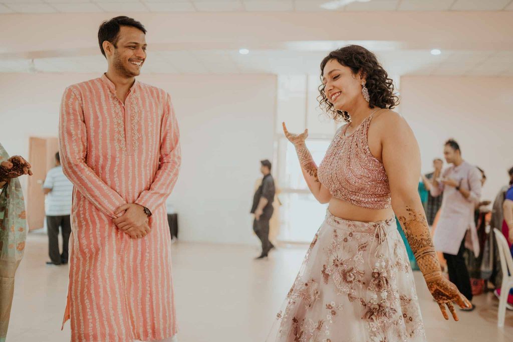 bride posing in front of groom in mehendi ceremony