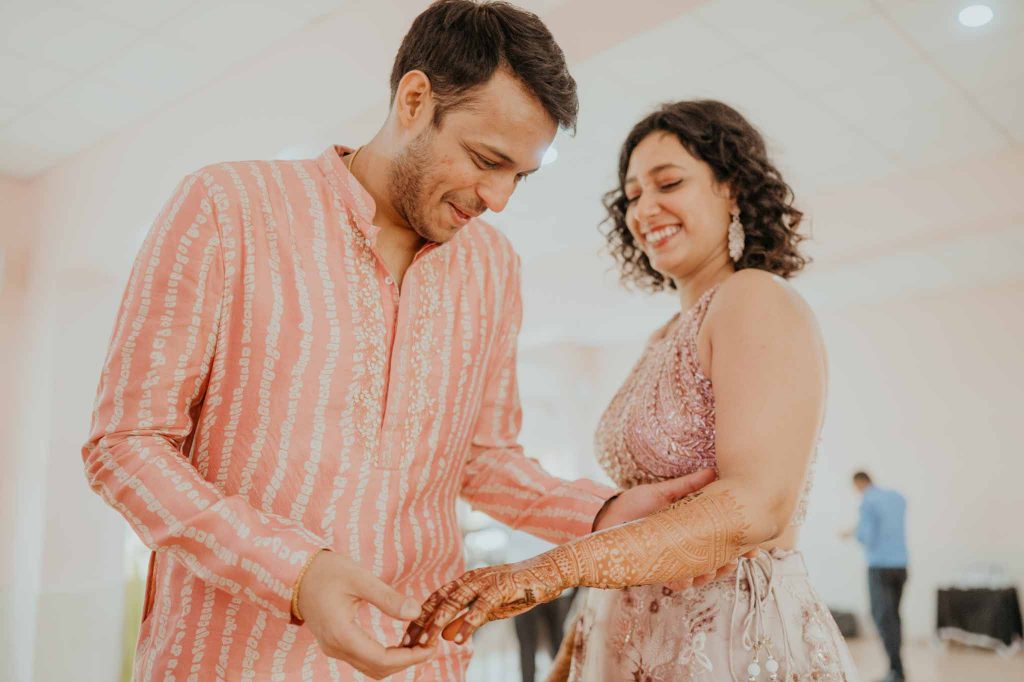 groom searching his name in bride's mehendi hand