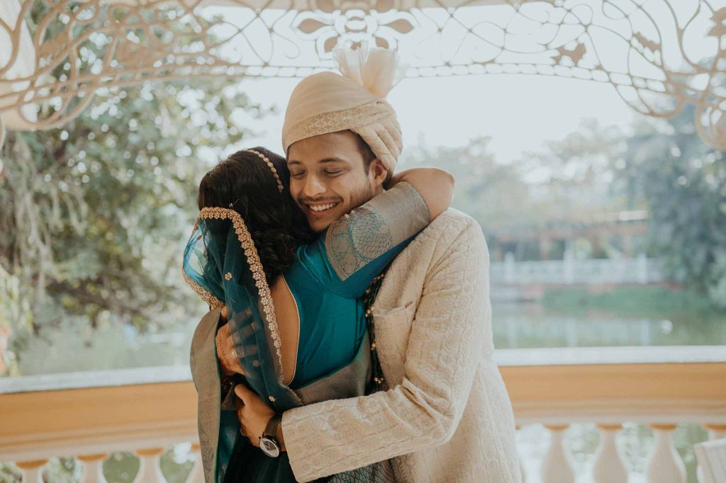 groom hugs bride on seeing her in front of lake view Mayfair lagoon Bhubaneswar