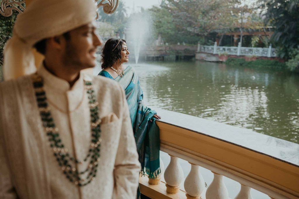 bride and groom in balcony looking towards lake in Mayfair lagoon Bhubaneswar