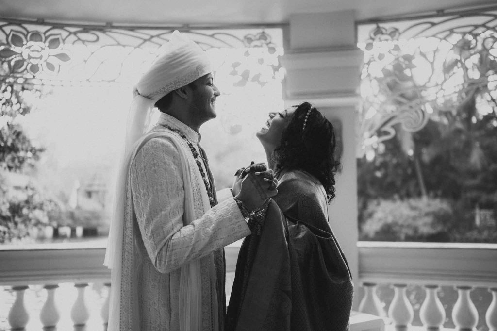 bride and groom face each other and talk in front of lake in Mayfair lagoon Bhubaneswar